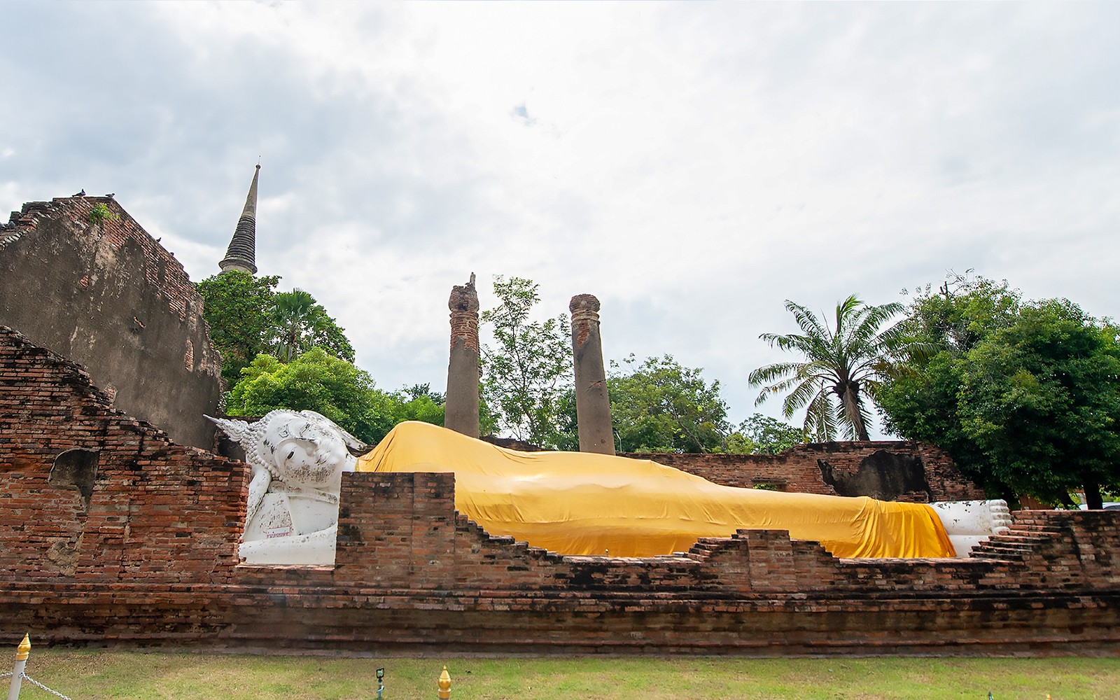 Liggende Buddha-statue i gul klæde ved Ayutthaya tempel, Thailand.