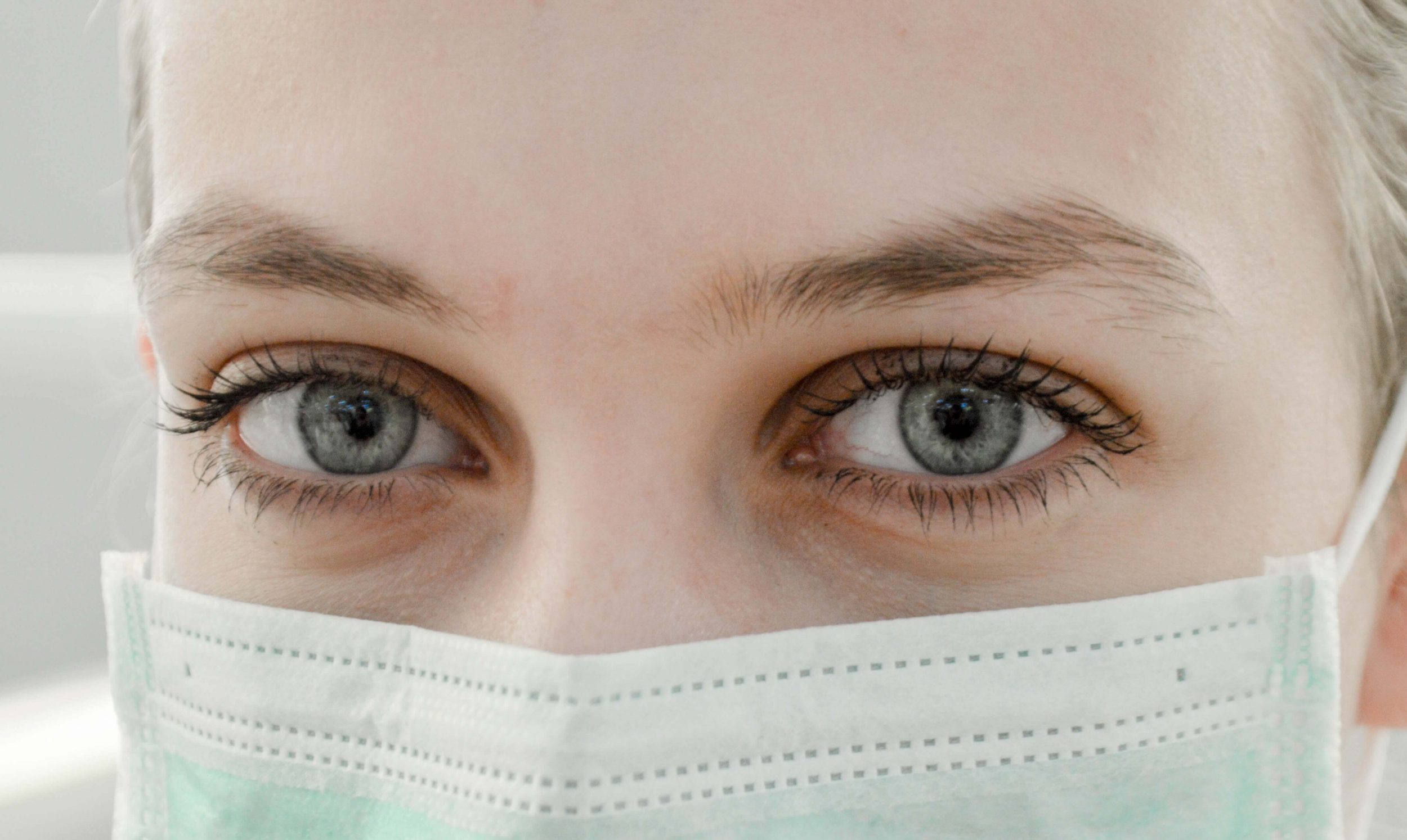 Close-up of a person wearing a surgical mask, highlighting telemedicine’s focus on remote healthcare and patient safety for a blog about Teladoc’s competitors.