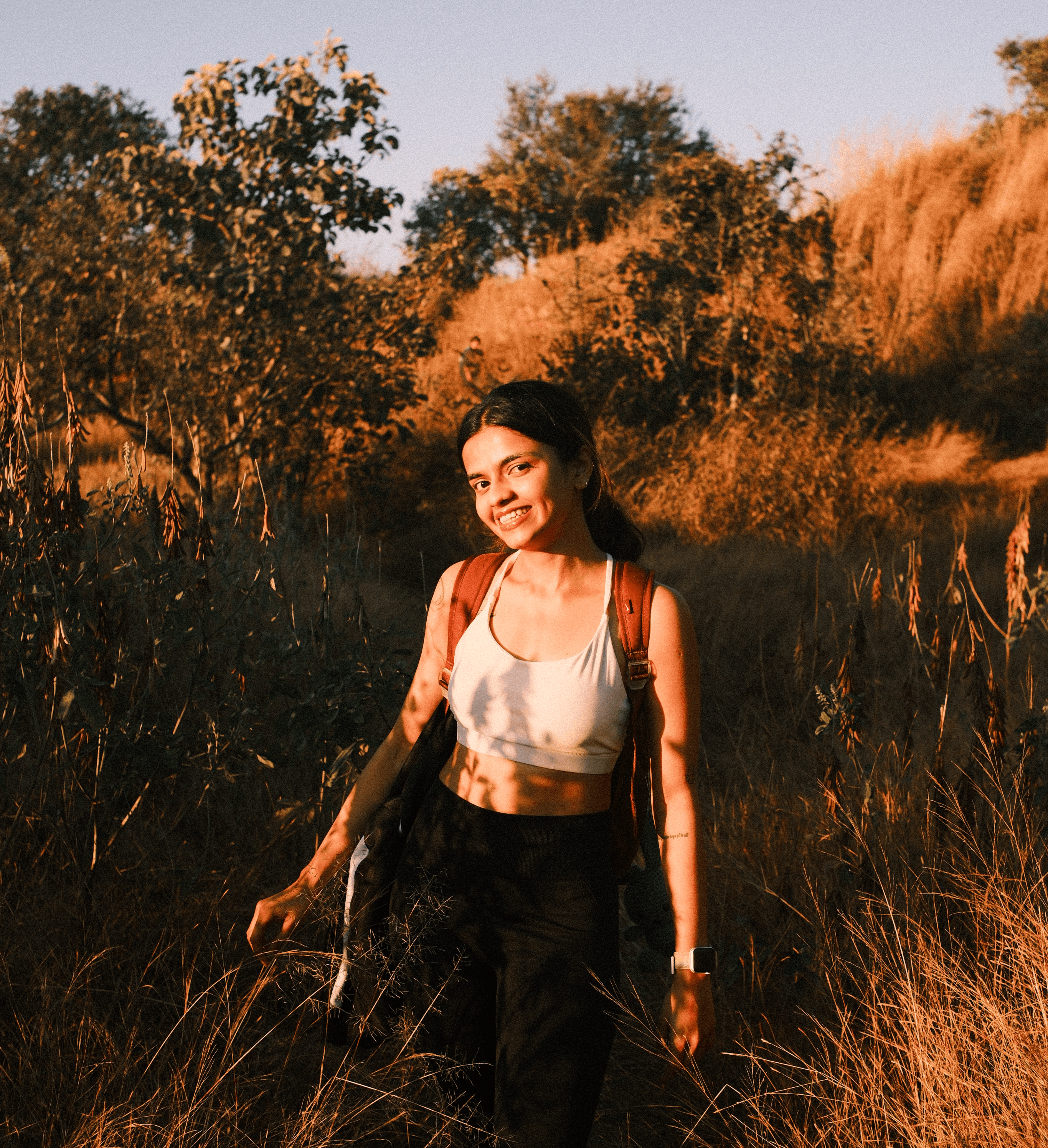 A modern, beige corner building with large windows and a sign reading "Think," surrounded by plants and trees. Motorcycles are parked nearby, with a relaxed, urban vibe.