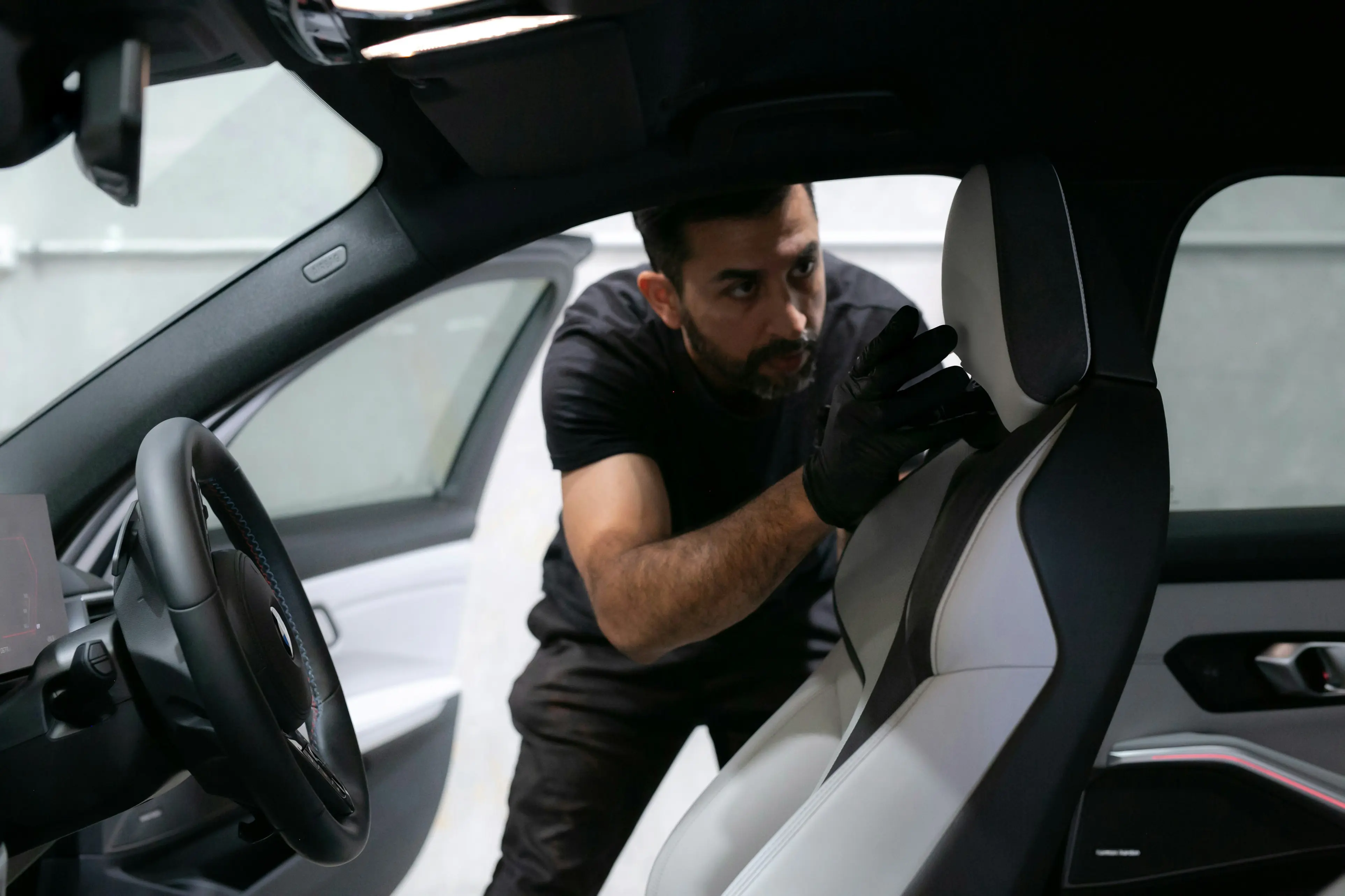 Person inspecting a vehicle interior as part of an auto repair estimate process.