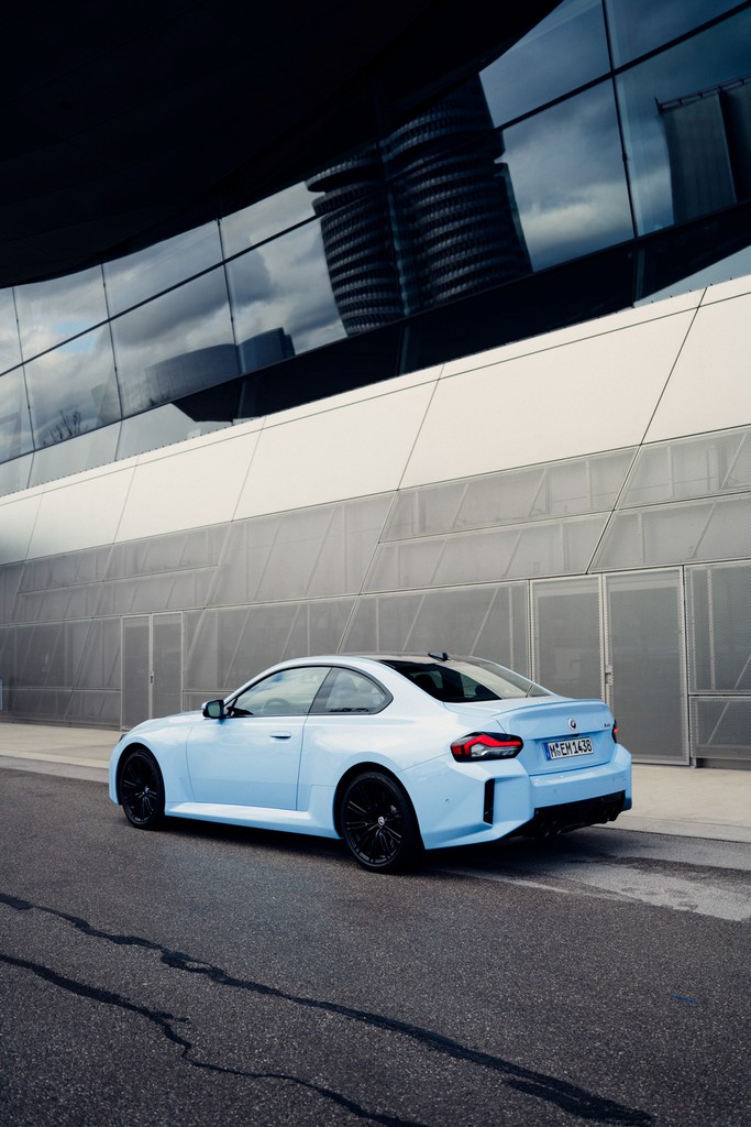 BMW M2 in baby blue positioned in front of a gray wall