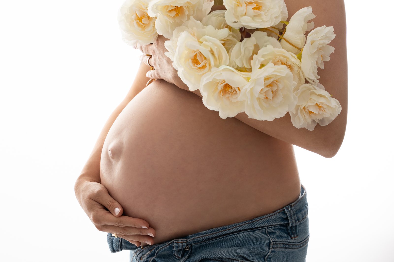 Babybauch mit Blüten im Studio