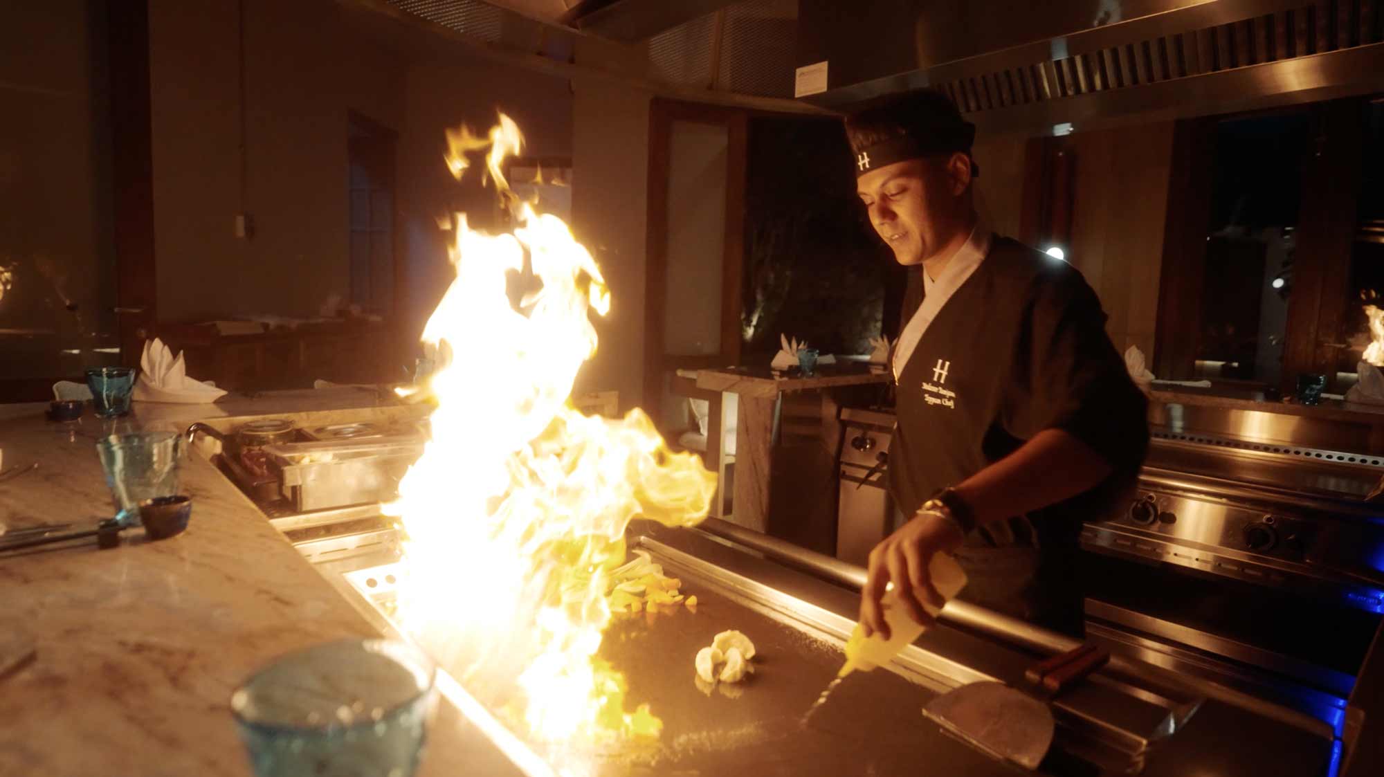 Chef performing flambé at grill; filmproduction ad for a hotel in mauritius