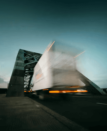 Semi-truck running under the bridge.