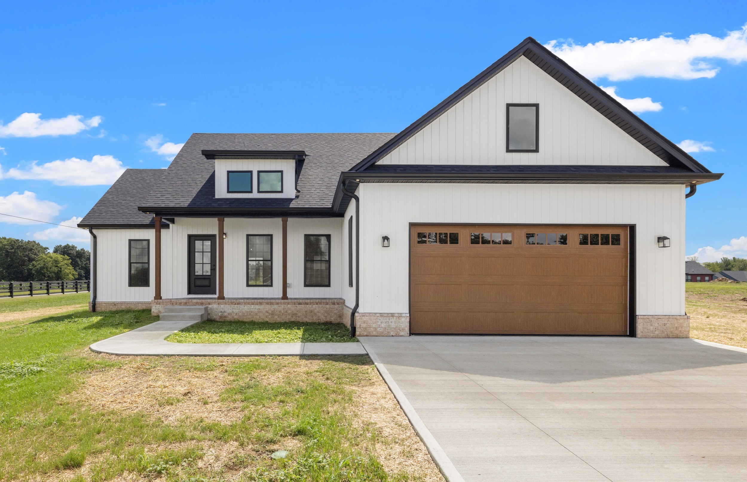 Modern indoor space with large glass doors, lush greenery, and a cozy seating area visible beyond.
