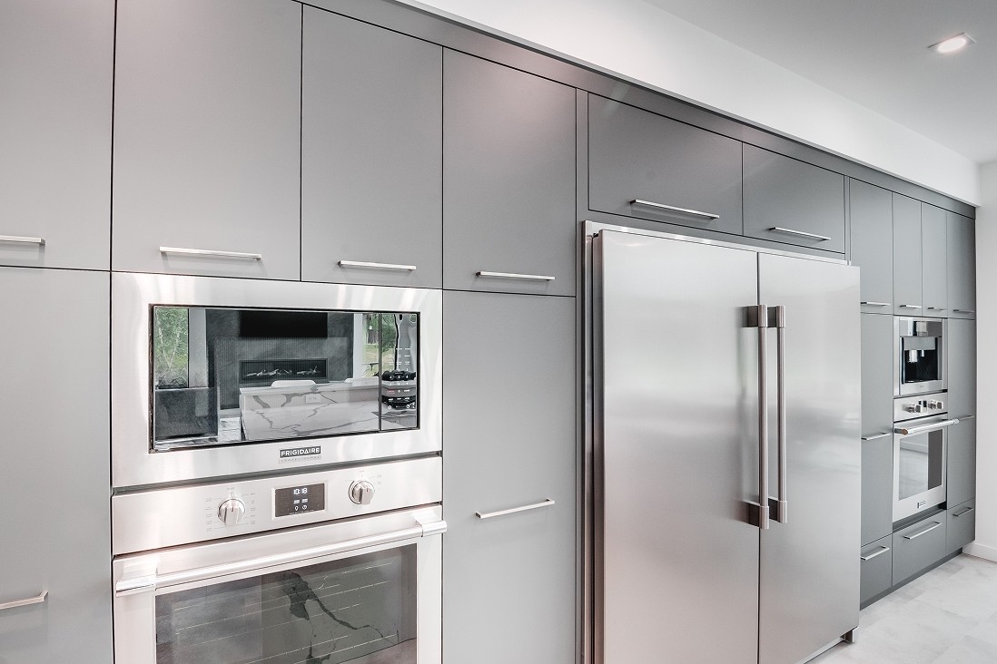 Fridge wall with sleek cabinets and built-in microwave