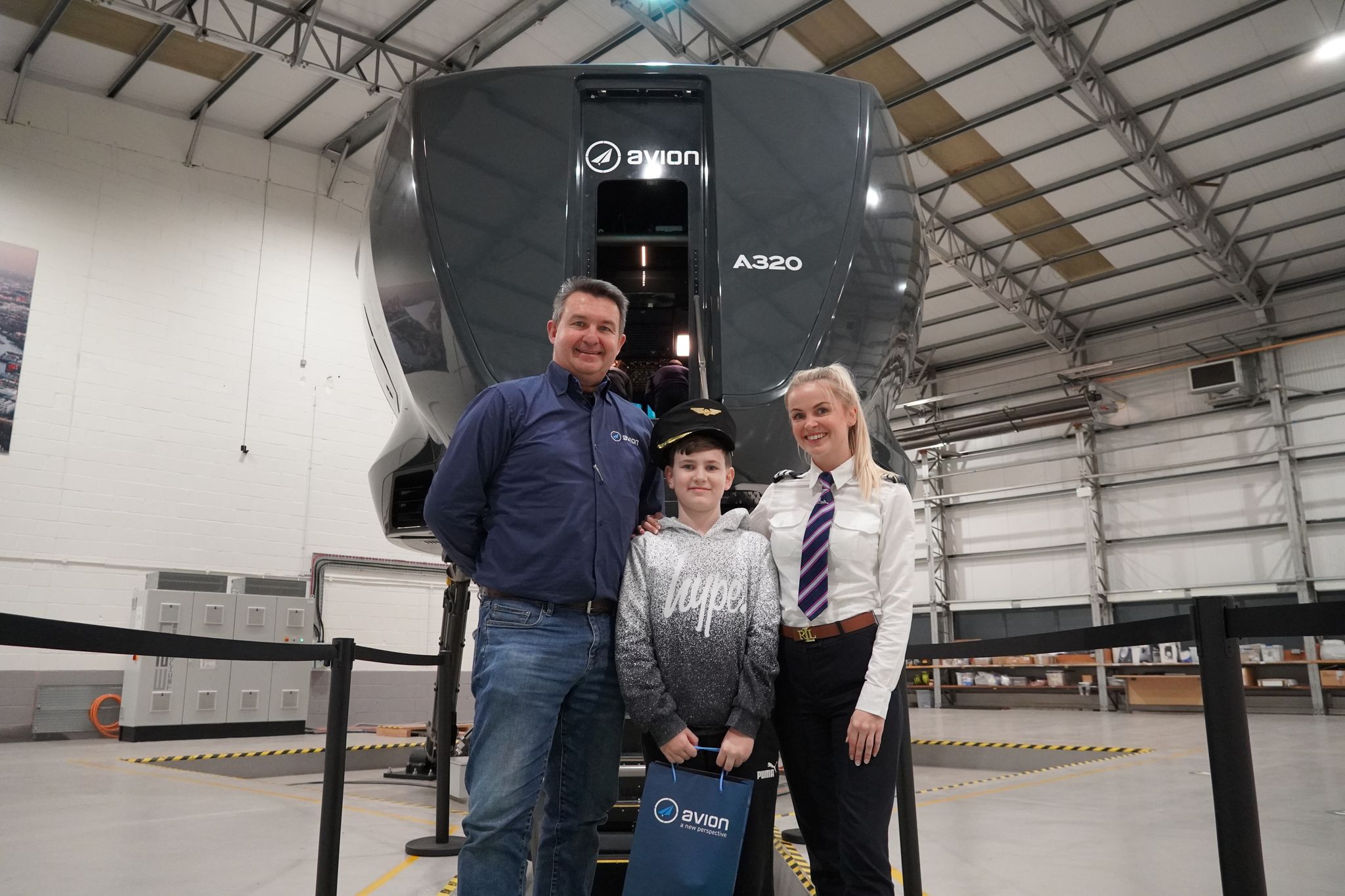 Ryan, Seth, and Michelle in front of the Avion Full Flight Simulator