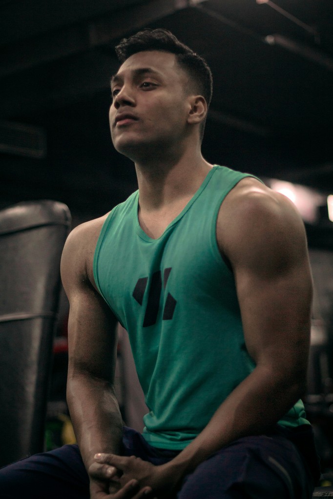 a man sitting on a bench in a gym