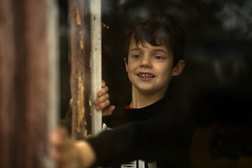 Dětská fotografie - kluk vyhlížející z okna