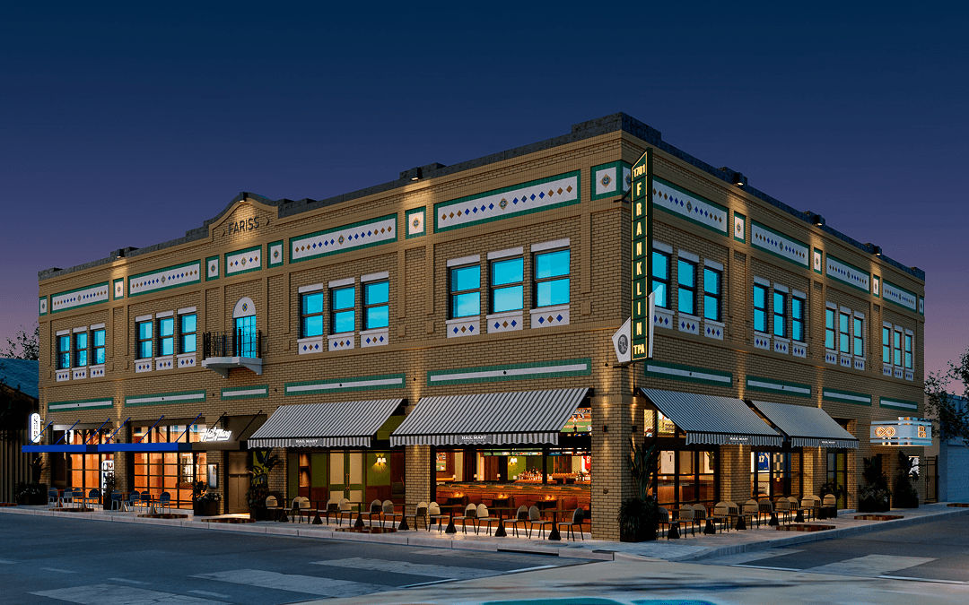 The historic Frederick P. Farris Building in Tampa Heights illuminated at night, featuring ornate yellow and blue brick architecture and storefront windows
