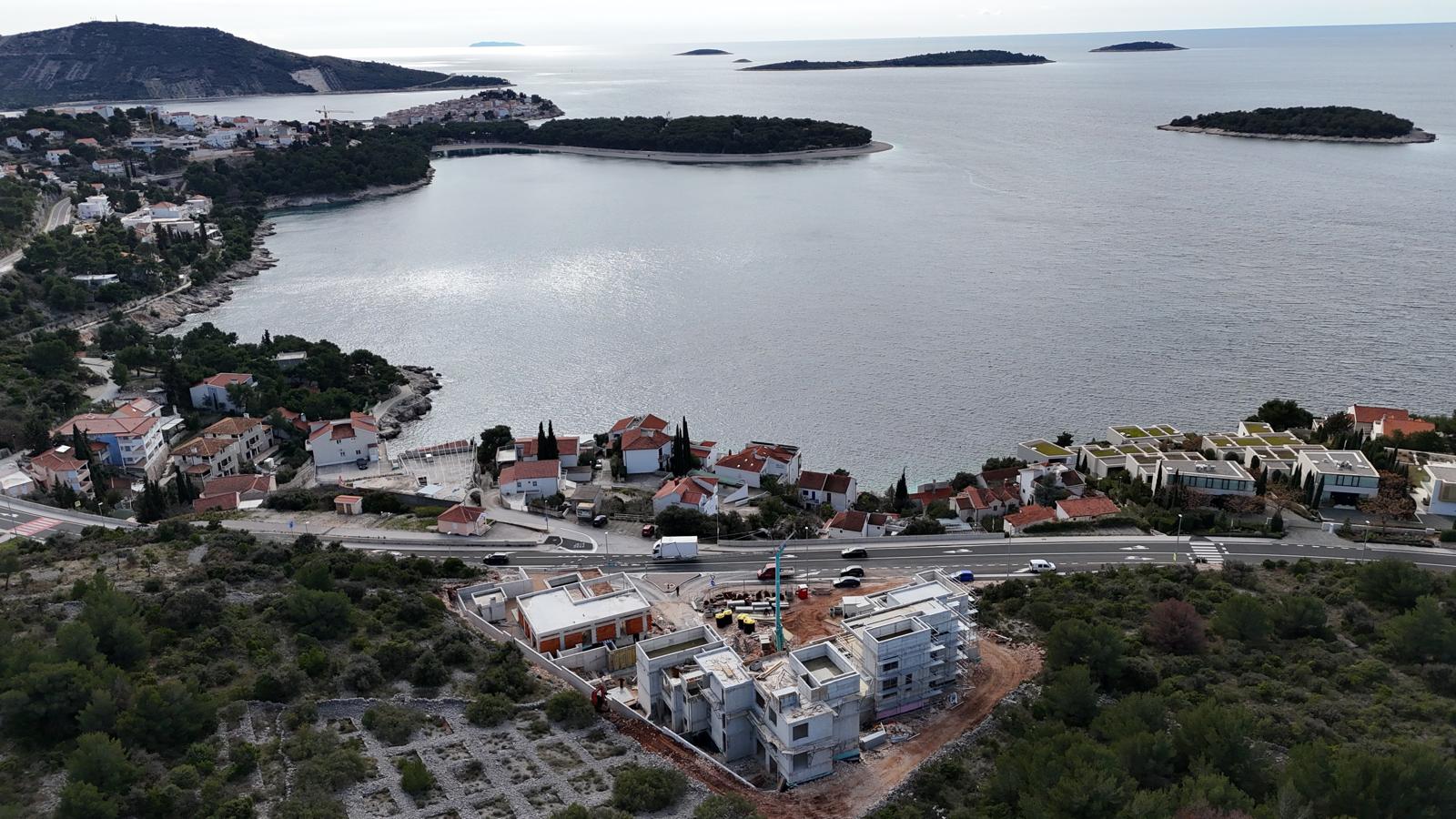 Black sports car in front of a modern, futuristic curved building.