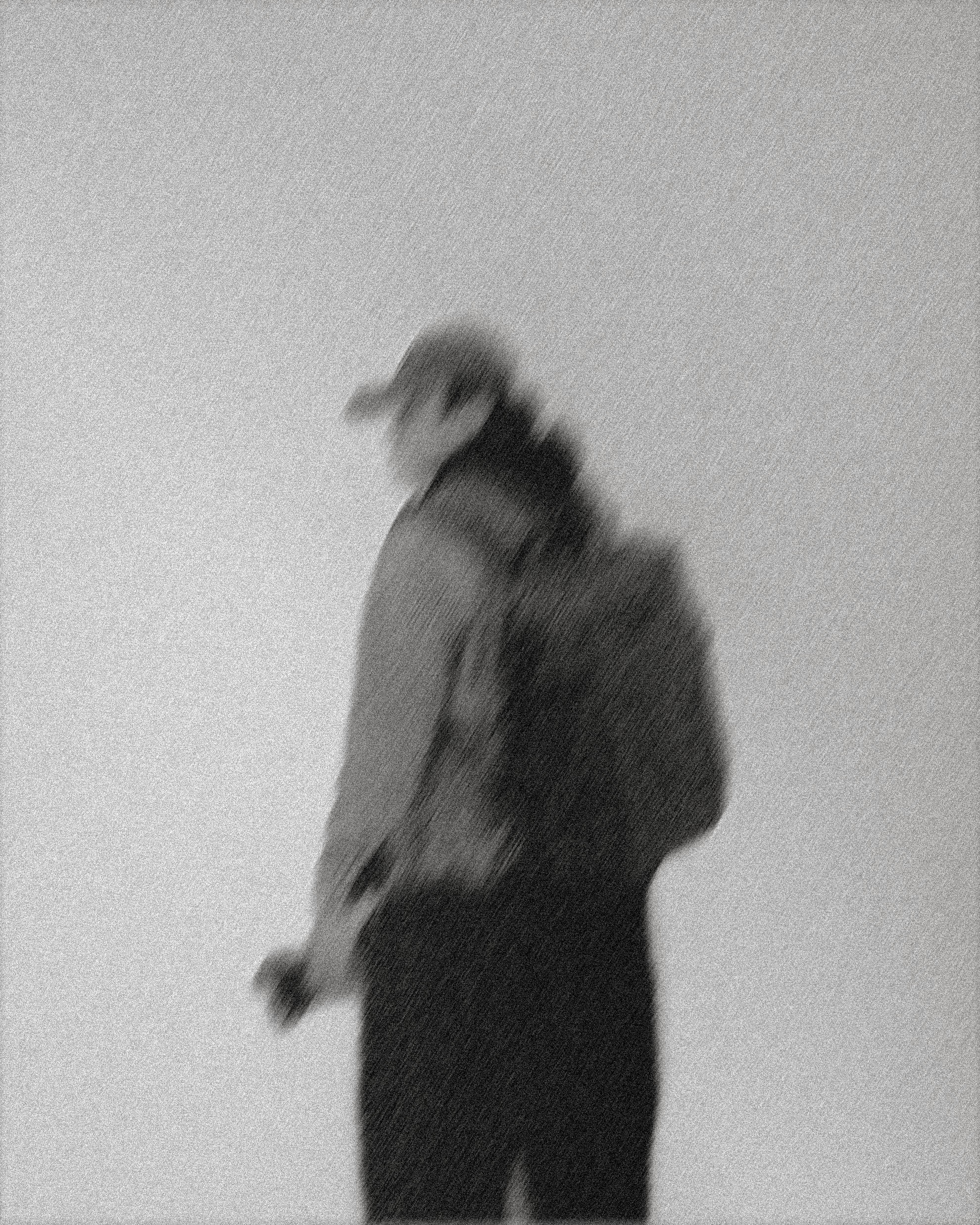 a blurry photo of a person standing in front of a wall