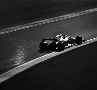 A formula 1 race car drving on a track.