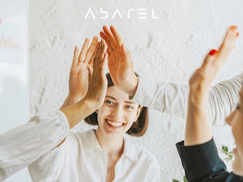 A group of people sharing a high-five in a office, embodying teamwork and collaboration at a boutique creative agency.