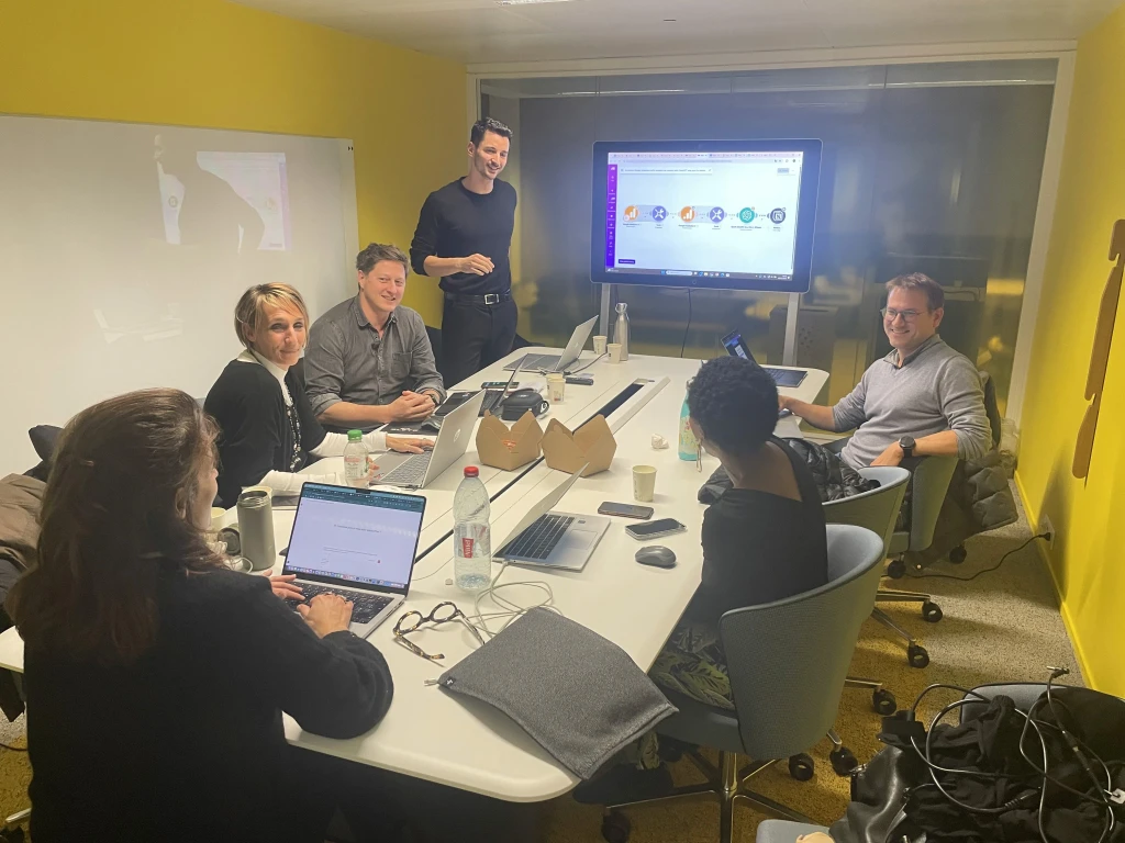 Groupe d'apprenants échangeant autour de leurs ordinateurs lors d'une formation FranceIA