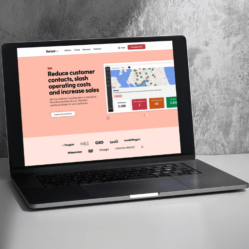 Laptop displaying Sorted homepage on a white desk against a gray wall