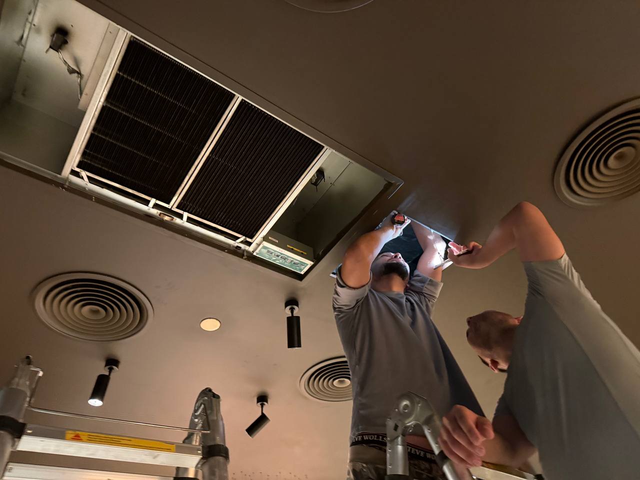 DENAIR technicians servicing commercial ceiling HVAC equipment