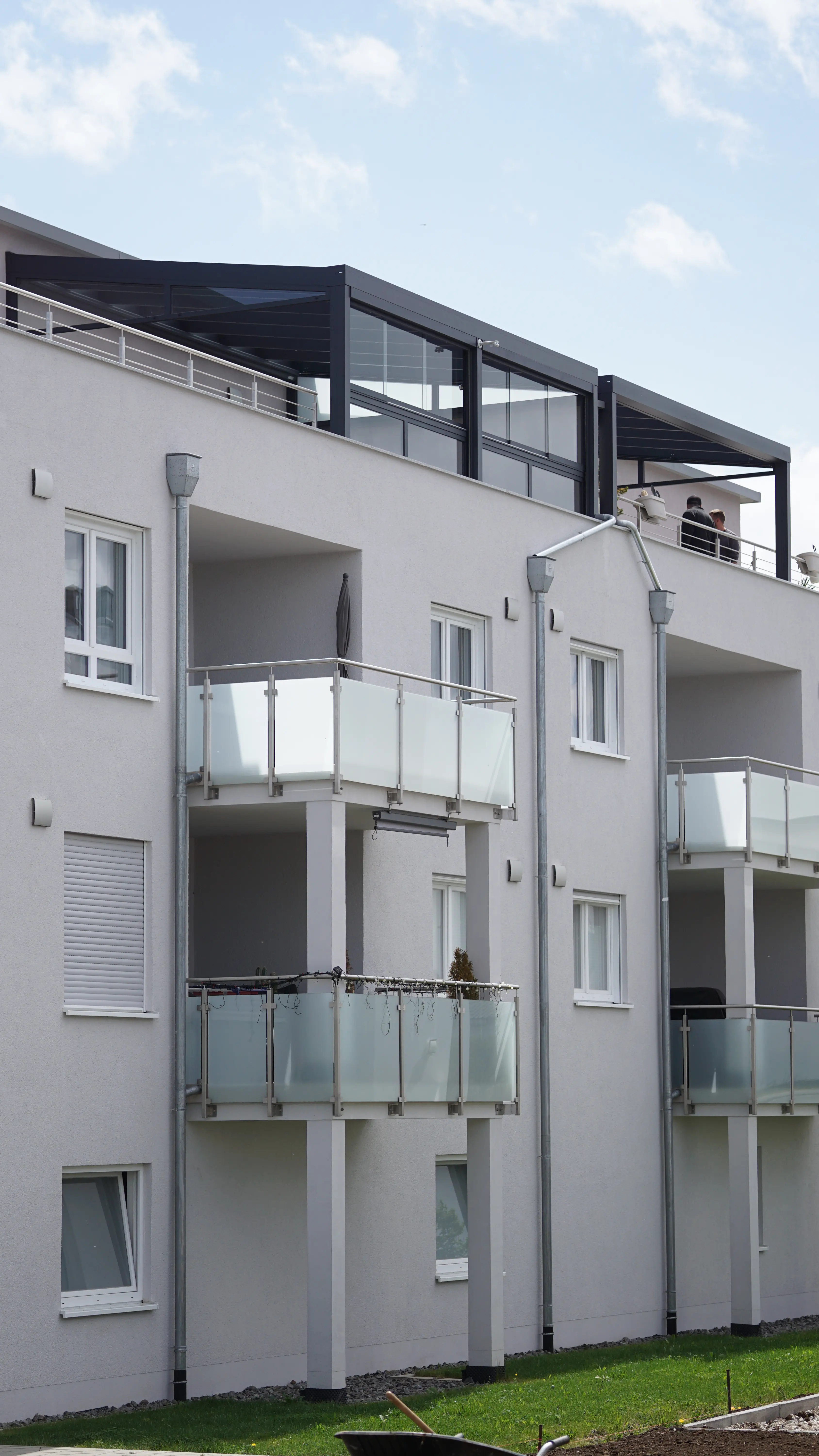 Mehrfamilienhaus mit verglaster Terrassenüberdachung auf der Dachterrasse