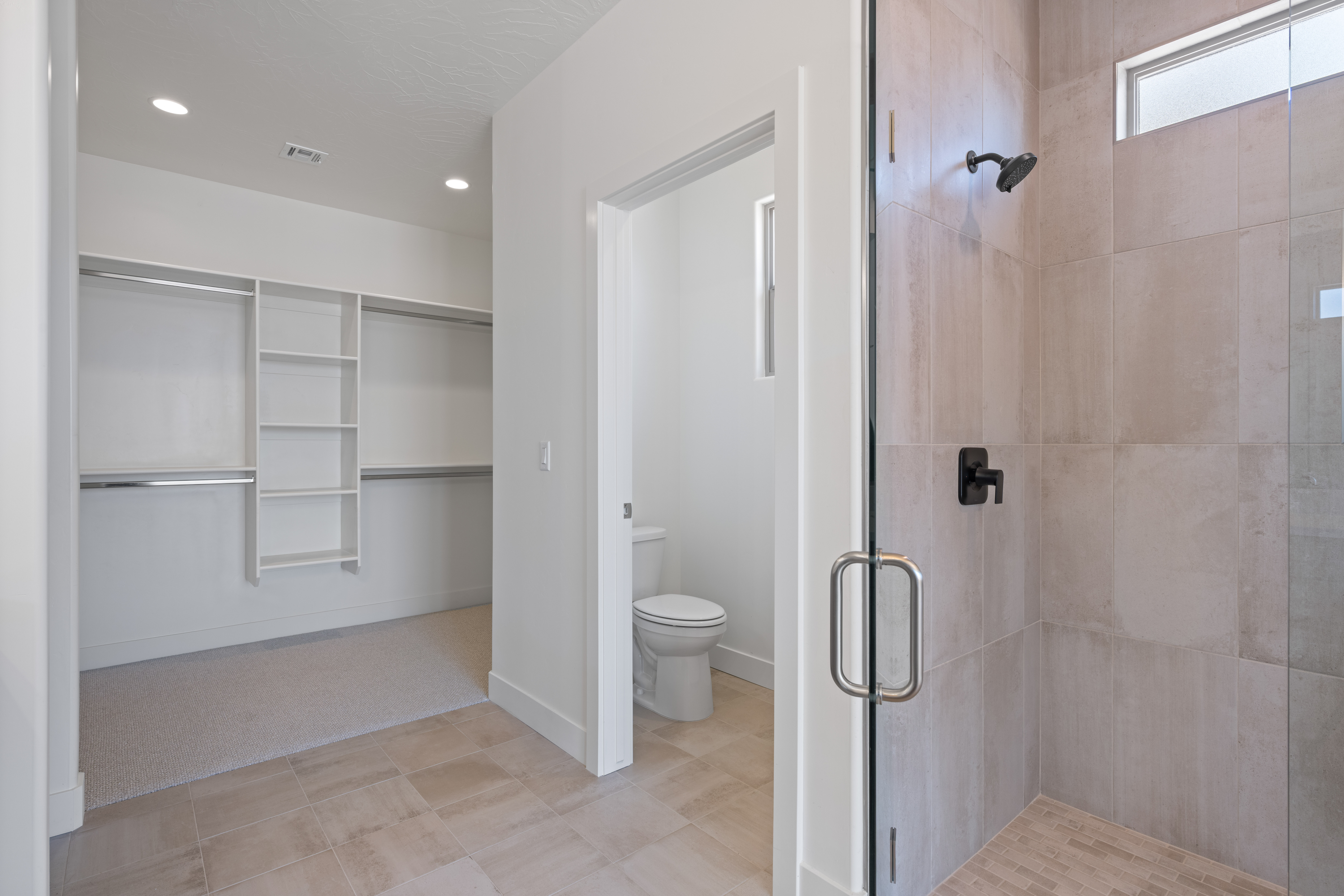 Master bedroom walk-in closet of The Nest at Falcon Ridge, showcasing shelving and organized layout.