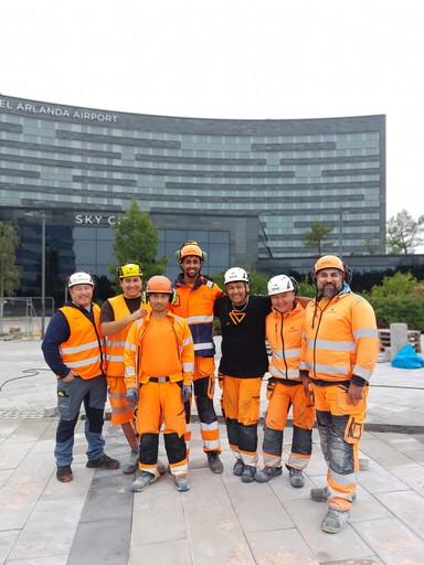 Imagem de Junte-se à Nossa Equipe: Um grupo de funcionários com uniformes de trabalho, sorrindo e posando juntos, representando o trabalho em equipe e a cultura da empresa.