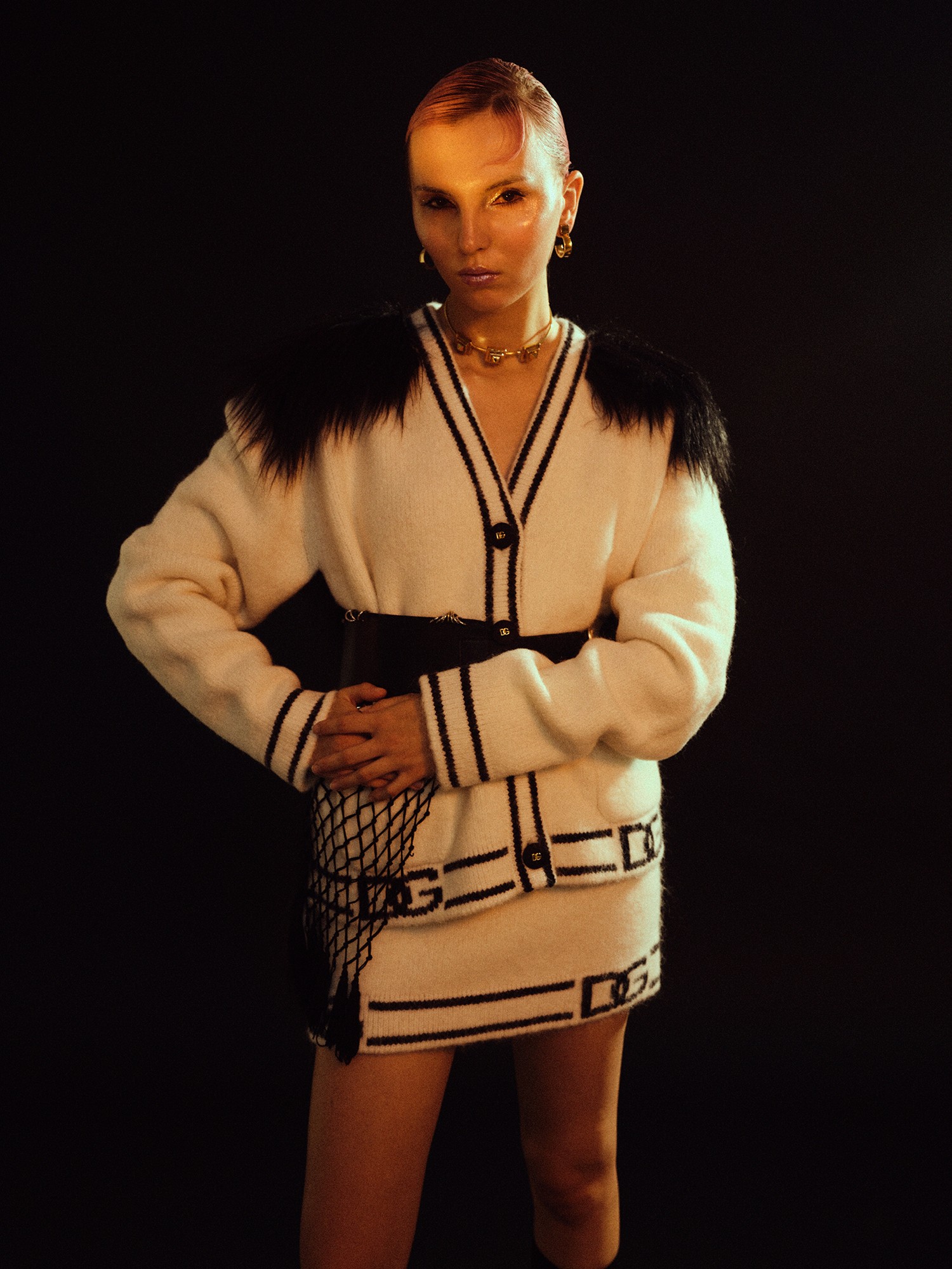 Detail of a cream knit outfit with dark geometric trim.