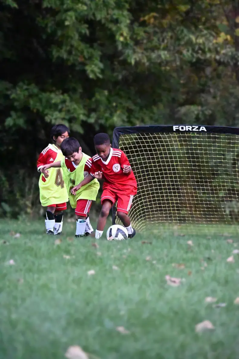 a young boy standing on a soccer field