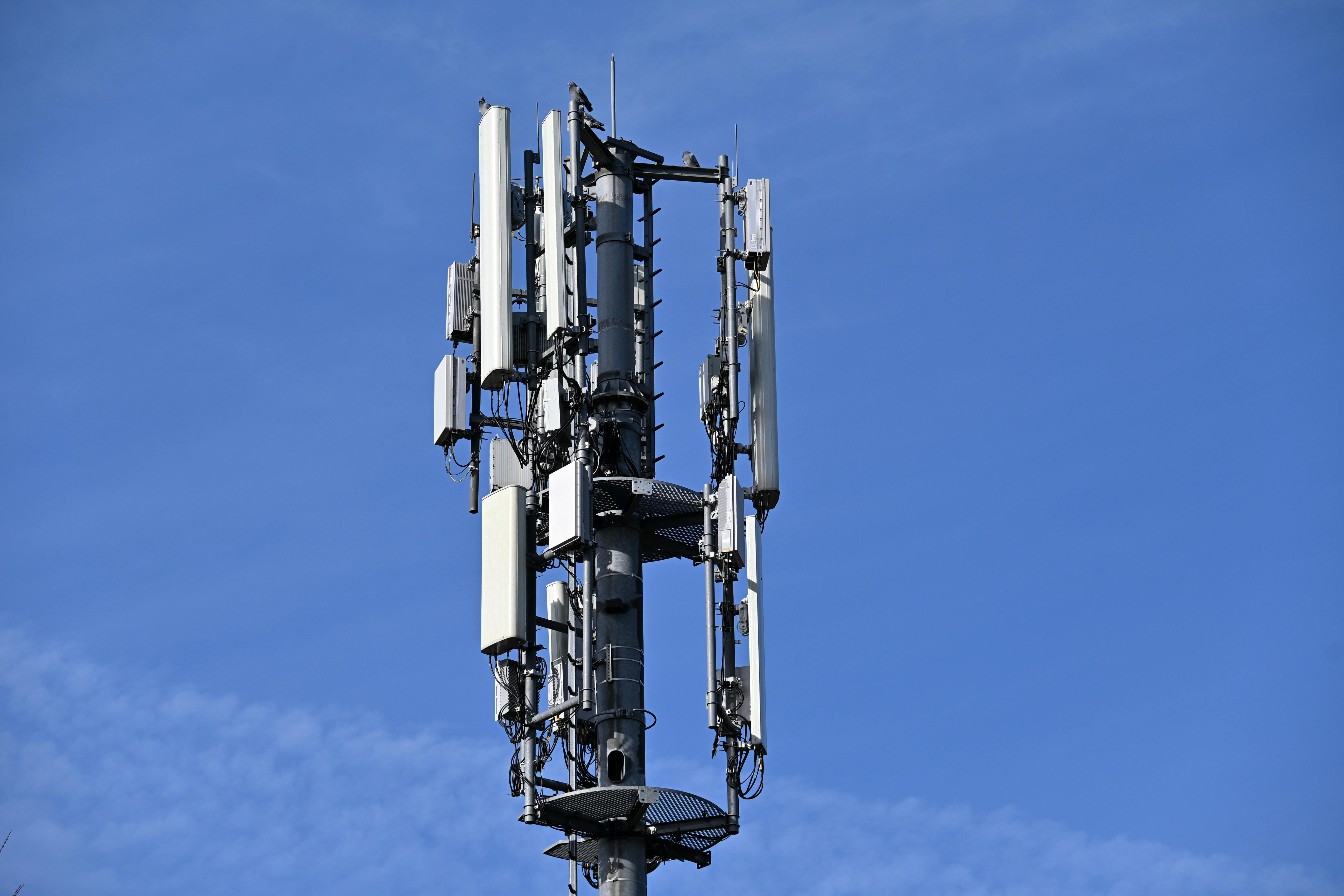 Cellular communication tower with antennas against a clear blue sky