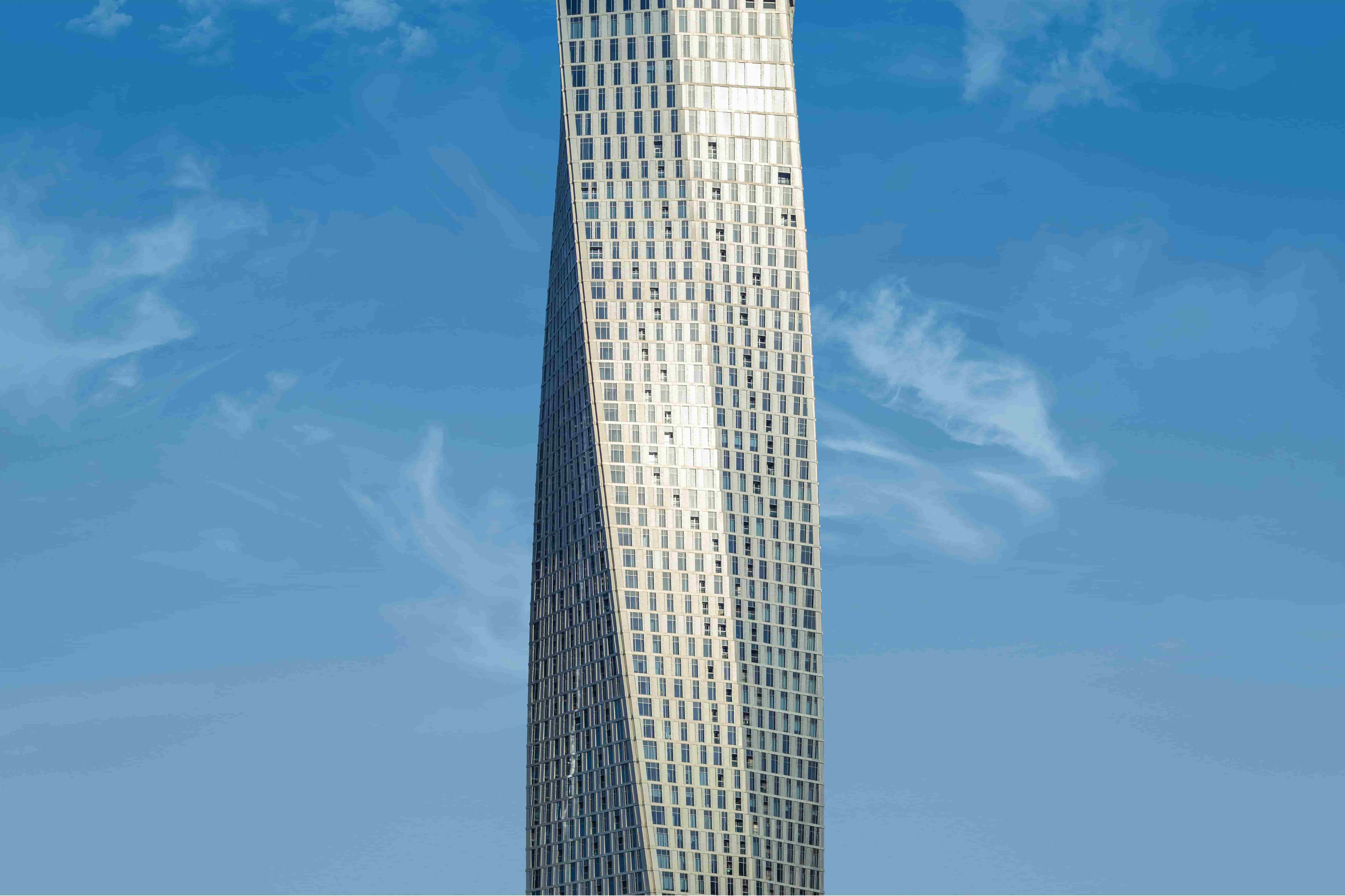The Cayan Tower in Dubai Marina set against a clear blue sky.
