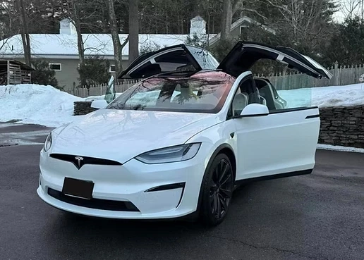 A white Tesla Model X with open falcon doors, showcasing professional exterior auto detailing and winter car care by Tony Mobile Detailing in Worcester.