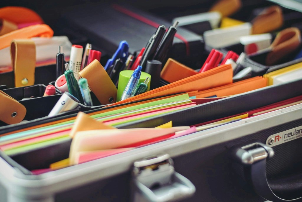 Office stationery supplies including pens and colored paper representing business products category