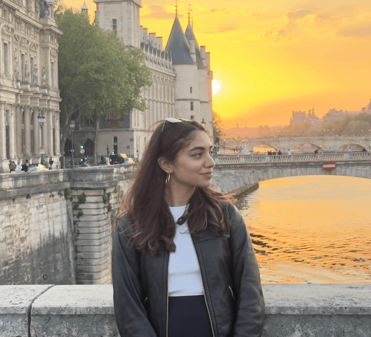A young person with long, wavy hair sits in front of a plain background, looking directly at the camera.