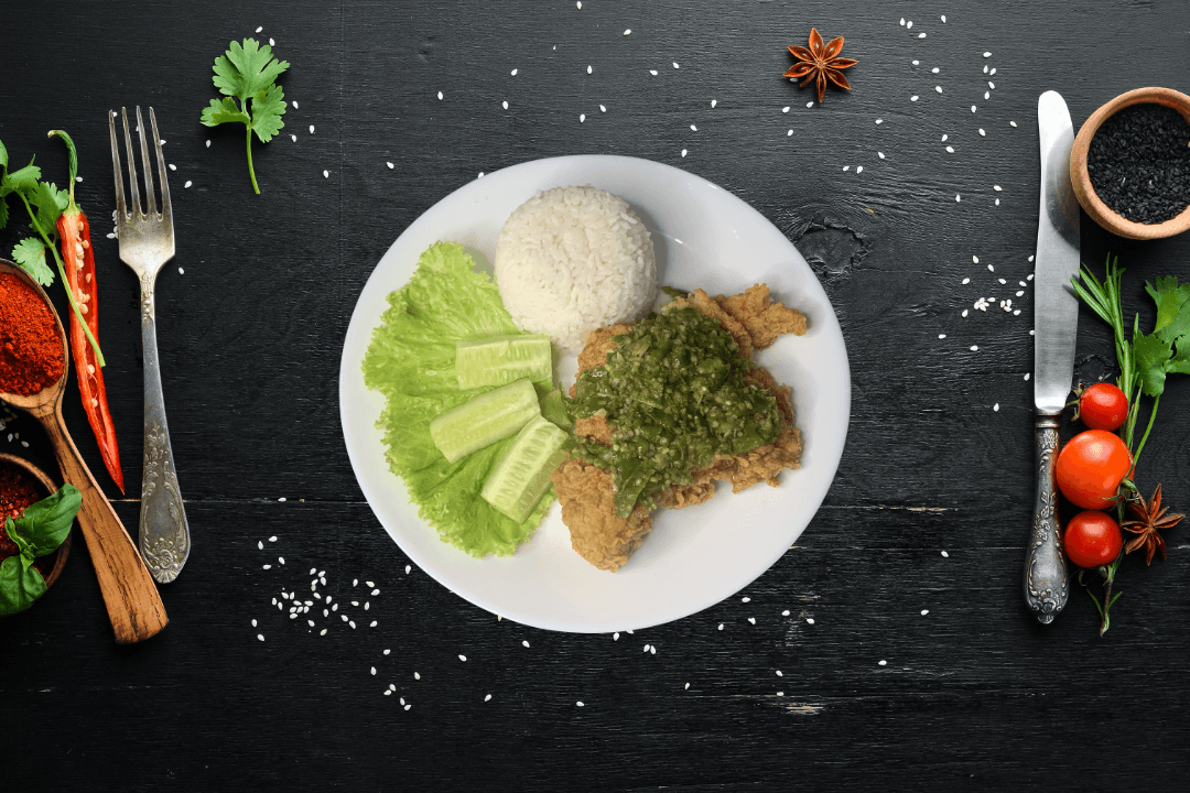 a glass of cocktail with a slime orange fruit