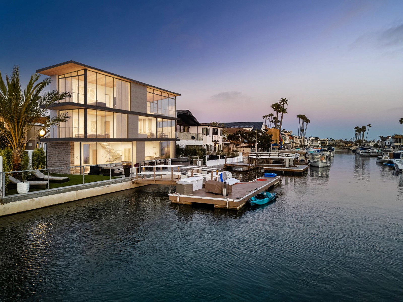 French-style luxury home with ornate arched doors, custom wrought iron gates, manicured driveway, and exterior lighting by top Los Angeles home builder.