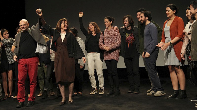 people raising hands and celebrating on a stage