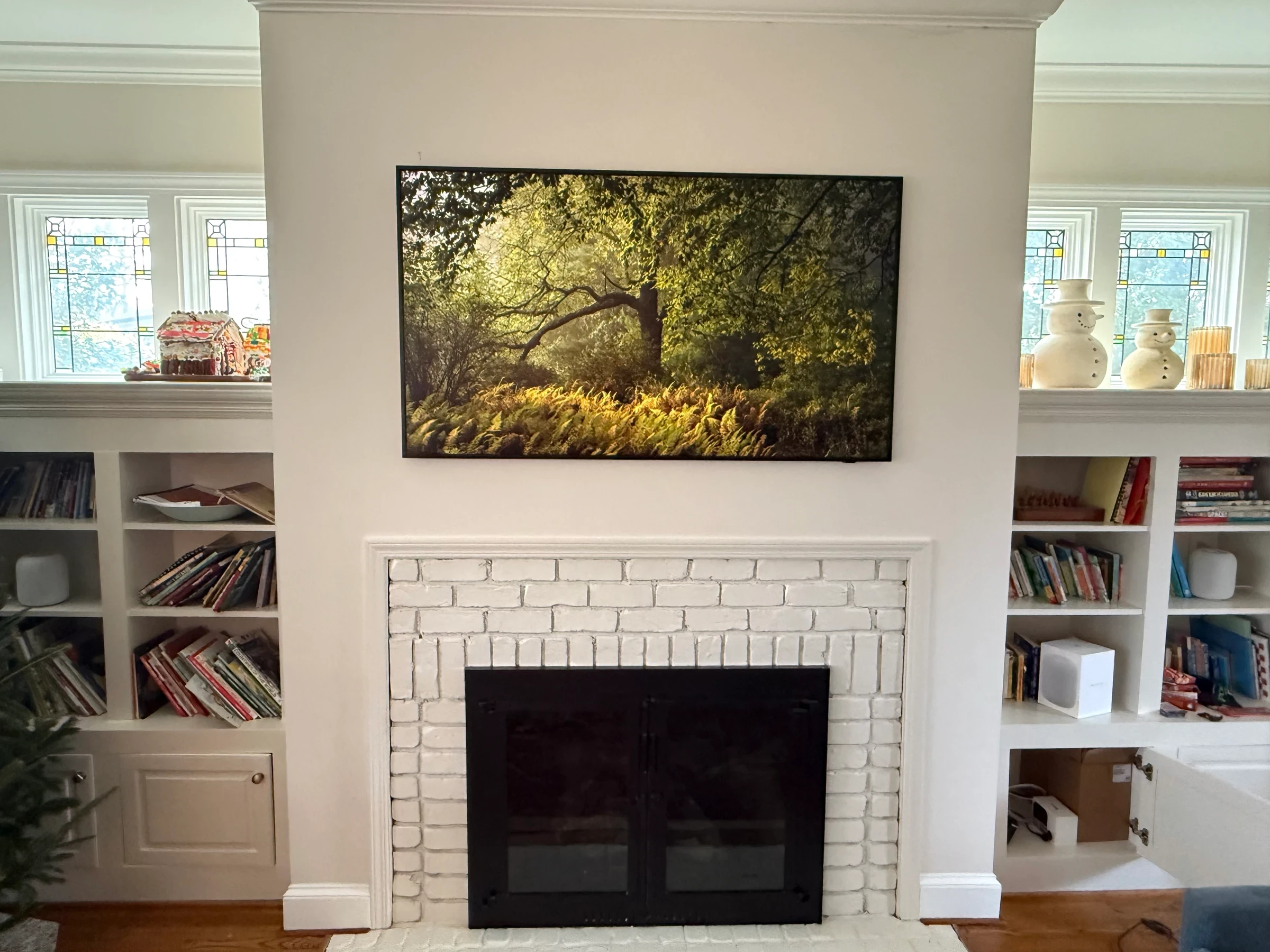 Forest image centered over a white brick fireplace and built-ins.