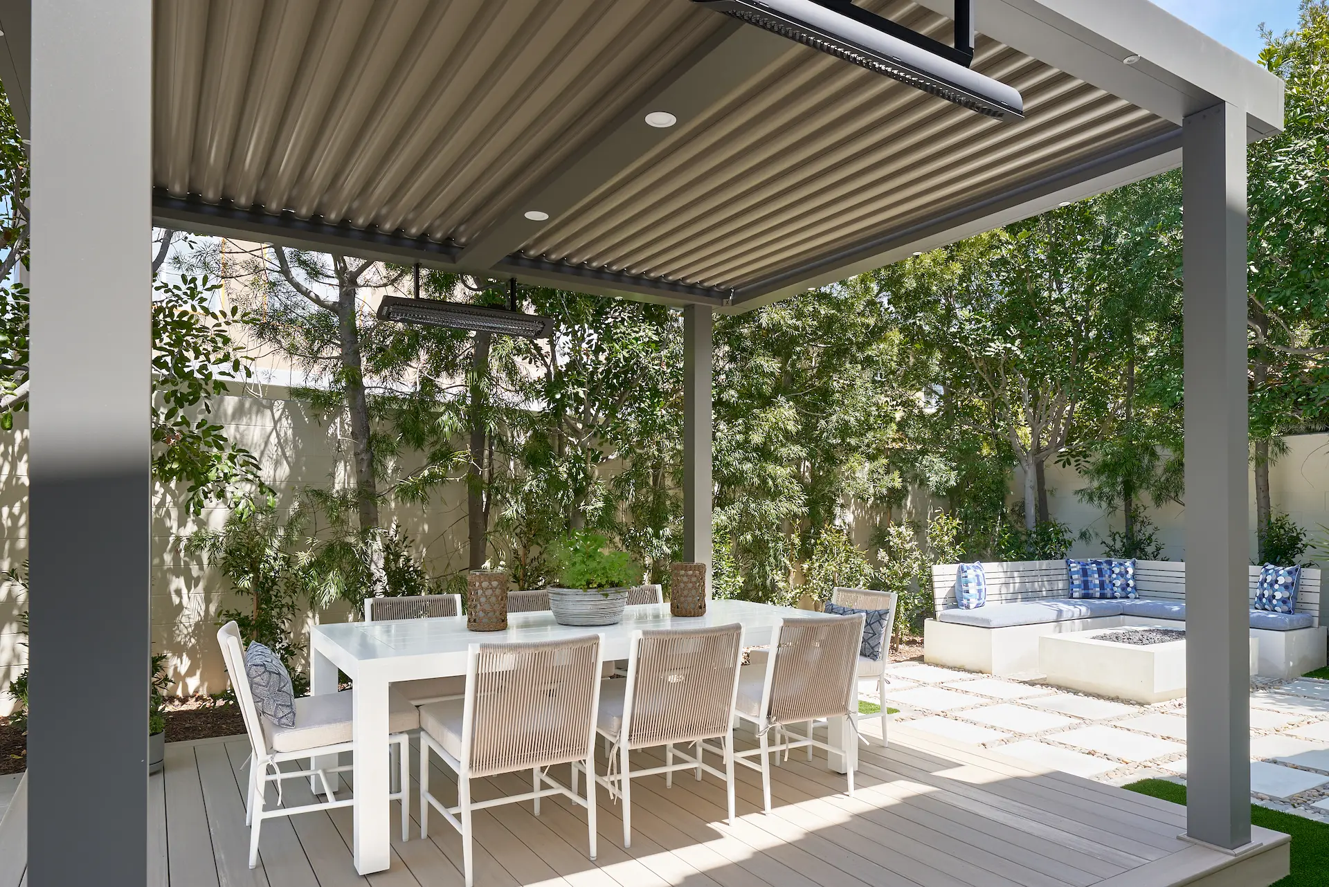 View of the exterior covered patio, showcasing seating arrangements and design in the Irvine Contemporary Coastal Remodel. Photo by Todd Huge.