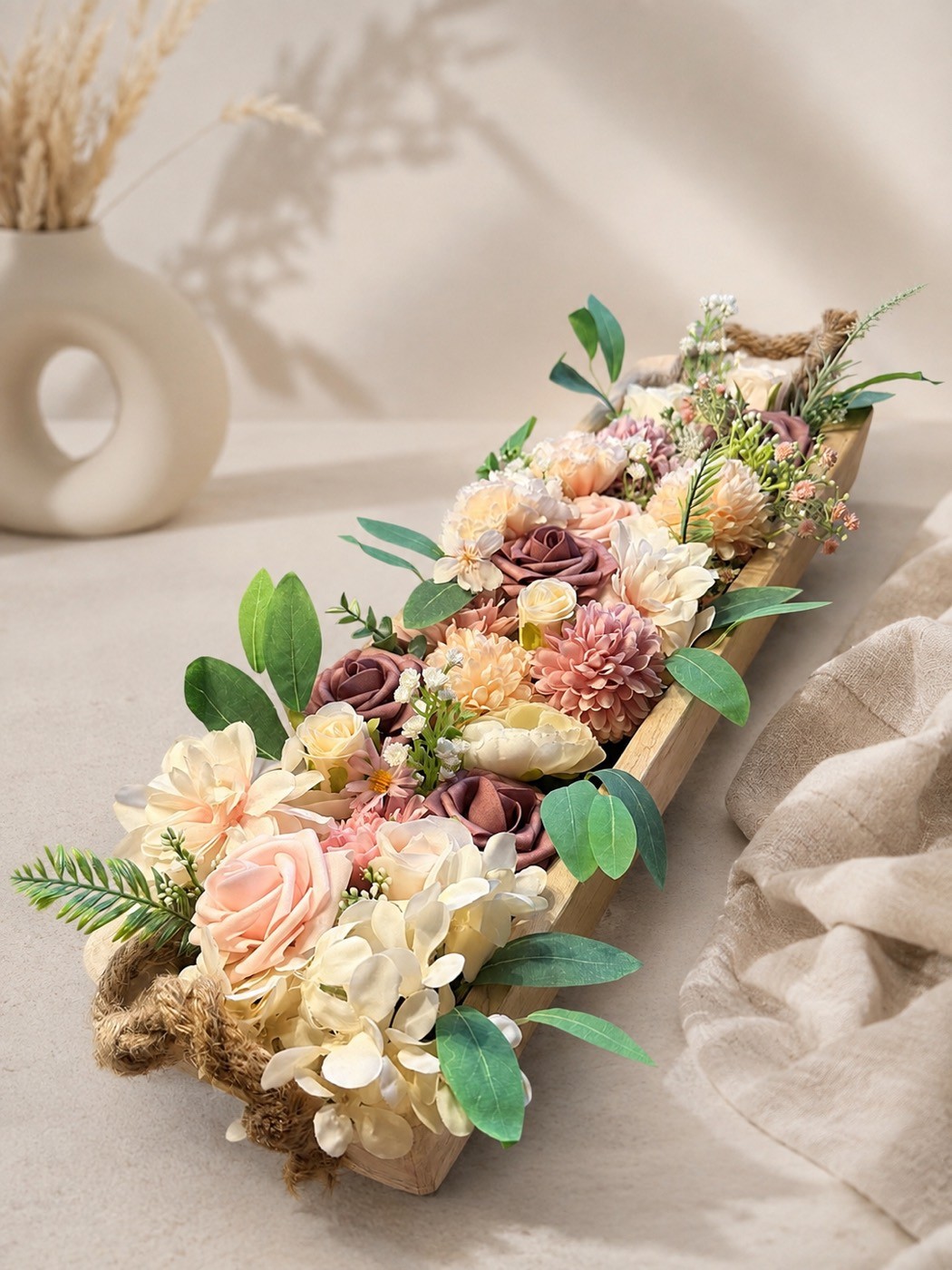 Helles Gesteck mit Trockenblumen in einer Holzschale