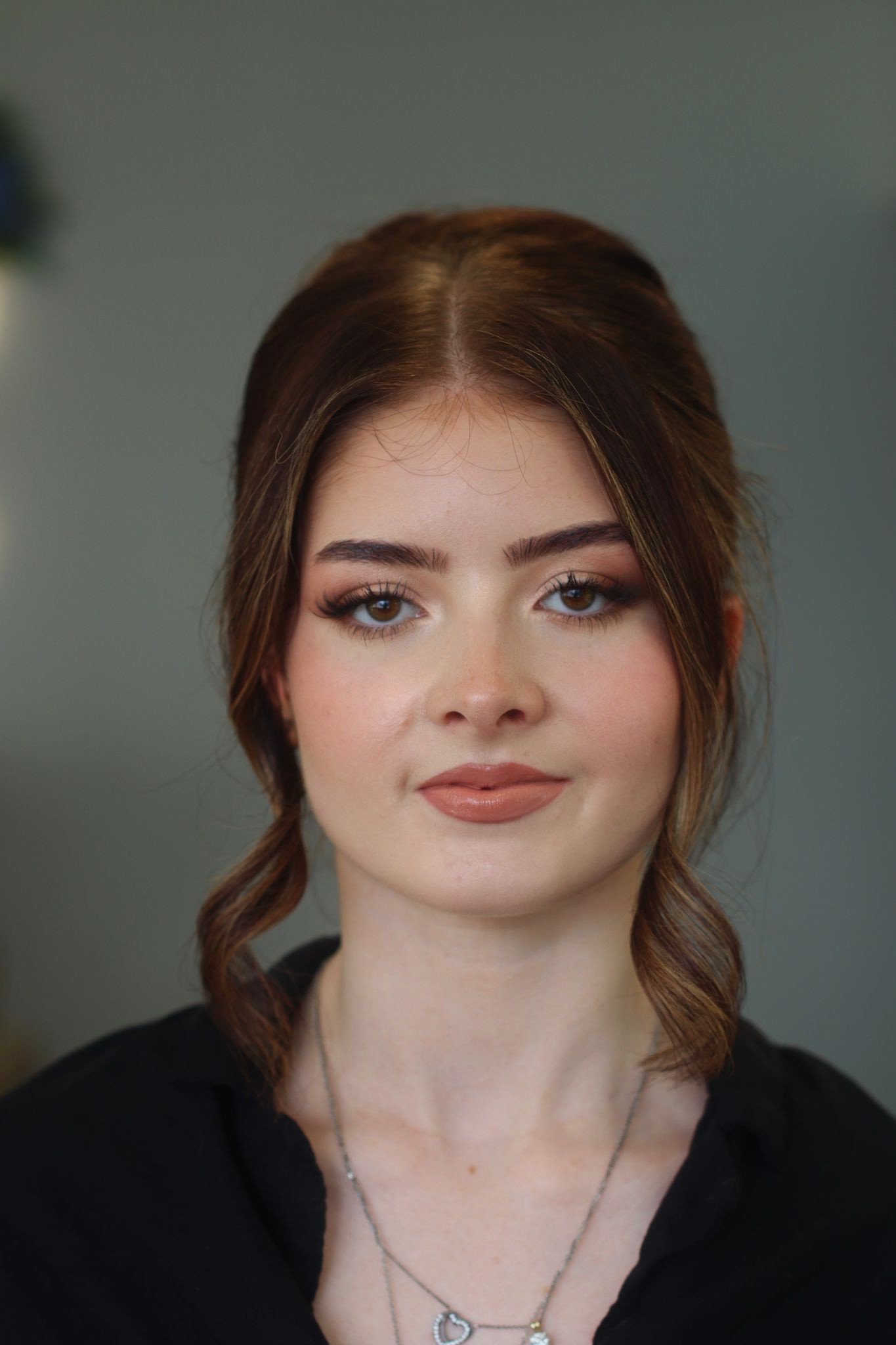 Flat lay of makeup essentials: brush, foundation, and powder on a beige background