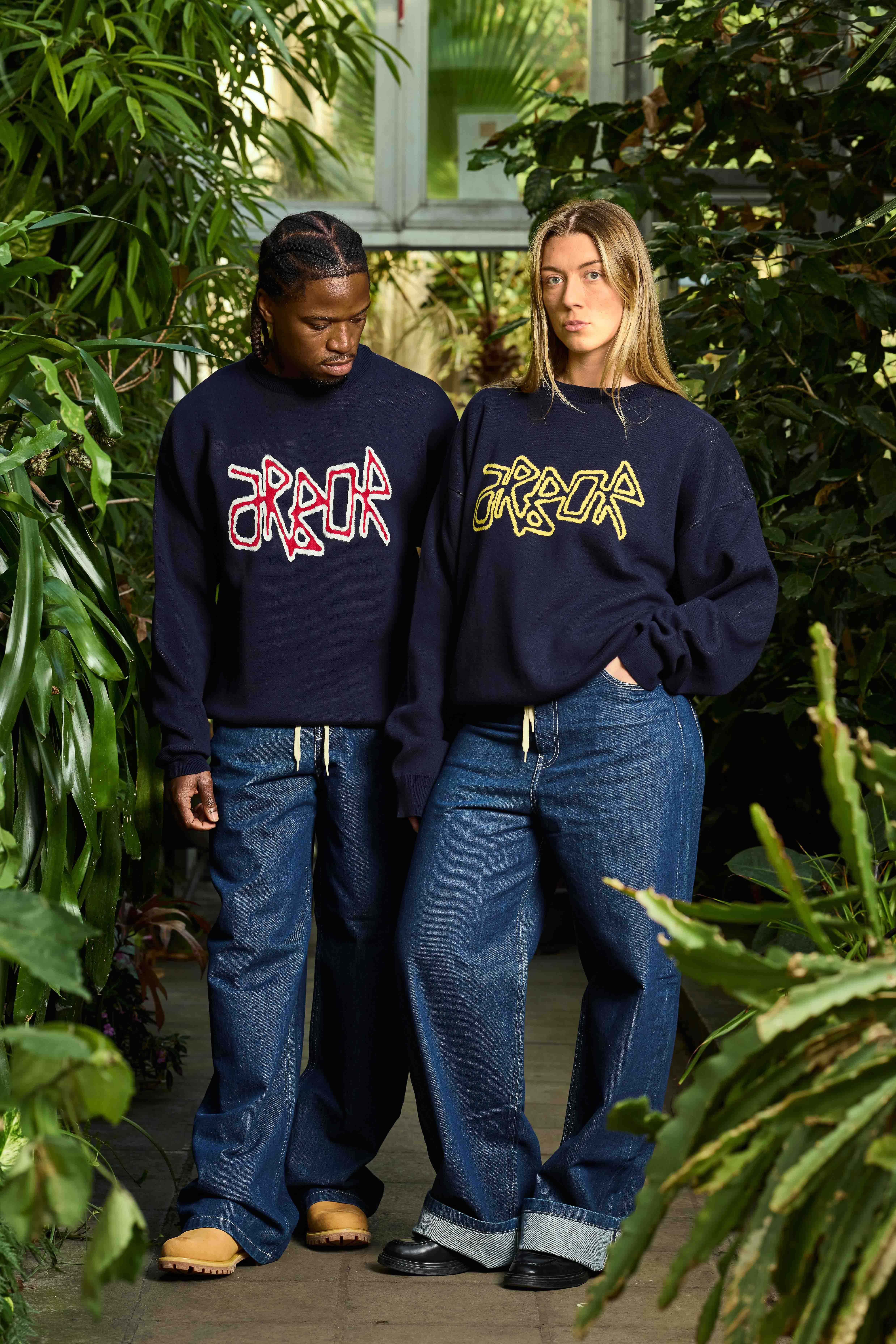 Un garçon et une fille portent des sweat-shirts imprimés du logo de lamarque Arbor Antwerpen dans un endroit plein de plante
