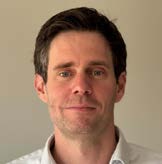 man in gray polo shirt smiling