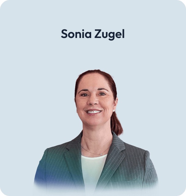 Porträt von Sonja Zugel, lächelnd im weißen Top und Blazer.