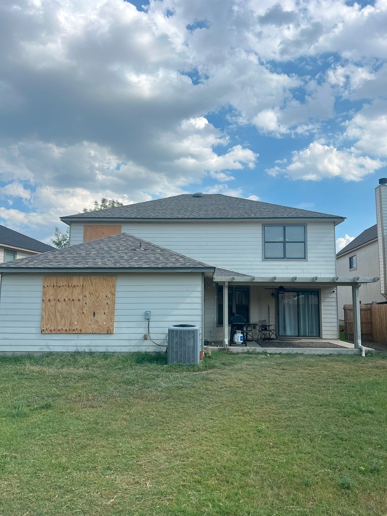 Two roofers at work. Nailing wooden battens on the roof with carpenter hammer or electric nailer