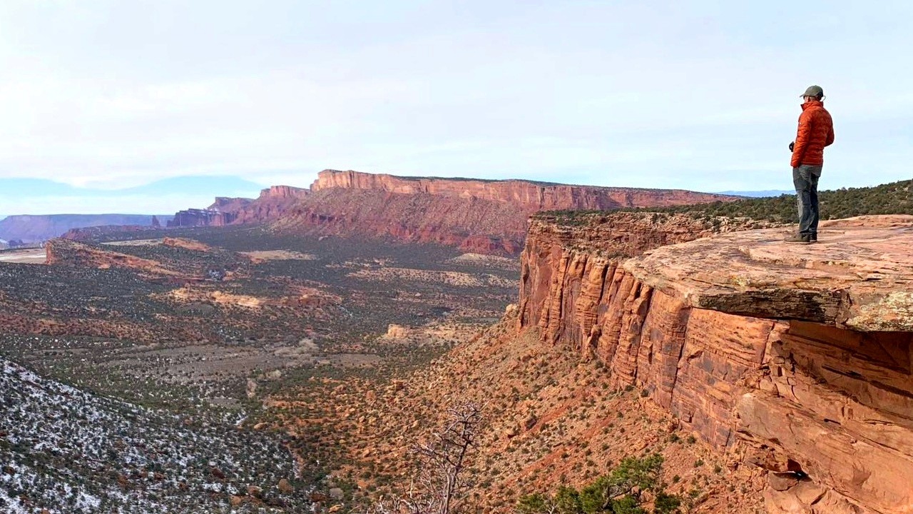 Man standing at the edge of a red rock cliff