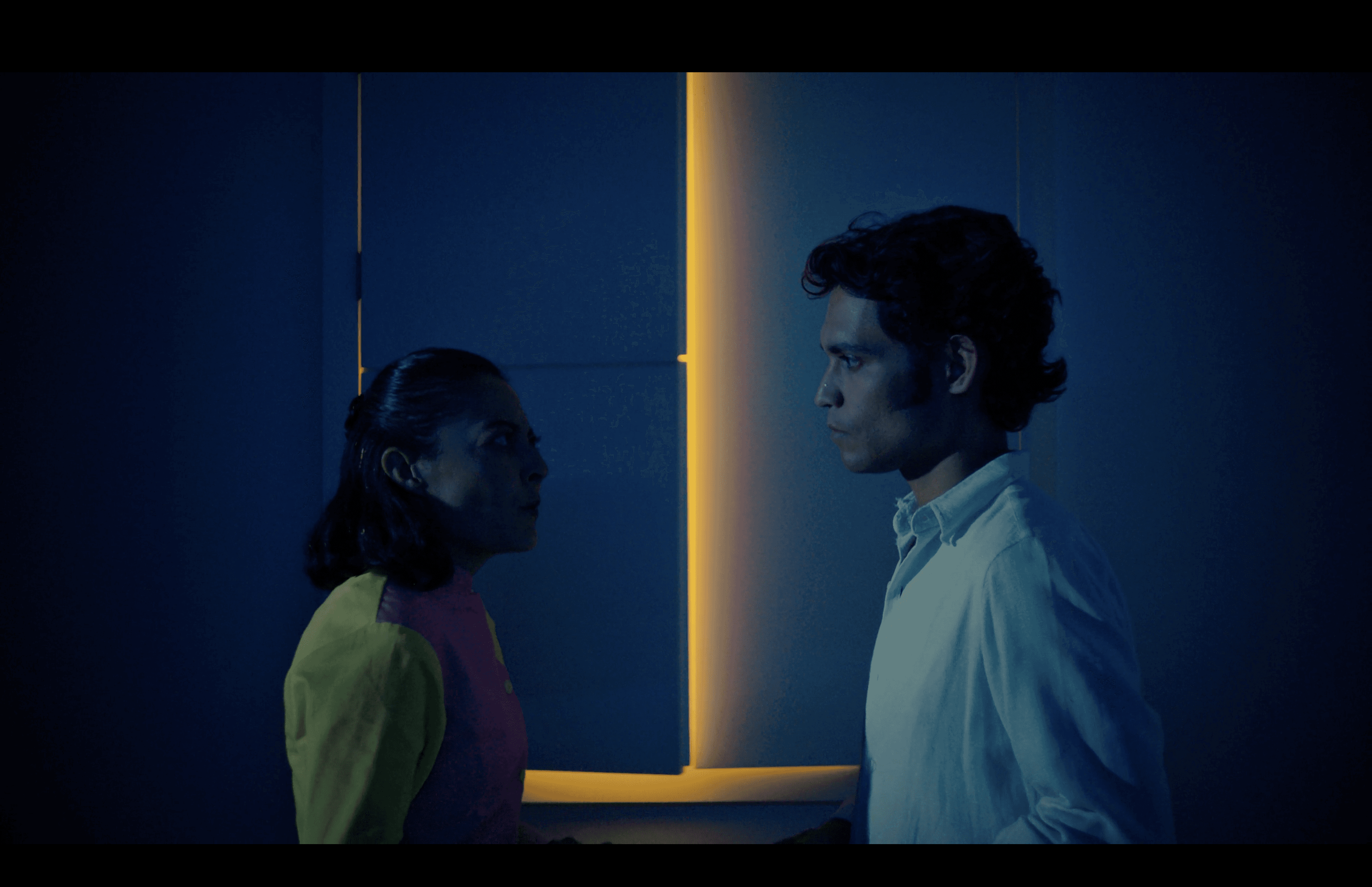 View of the French countryside through a stone villa’s open living room, with sofas and trees framing the scene