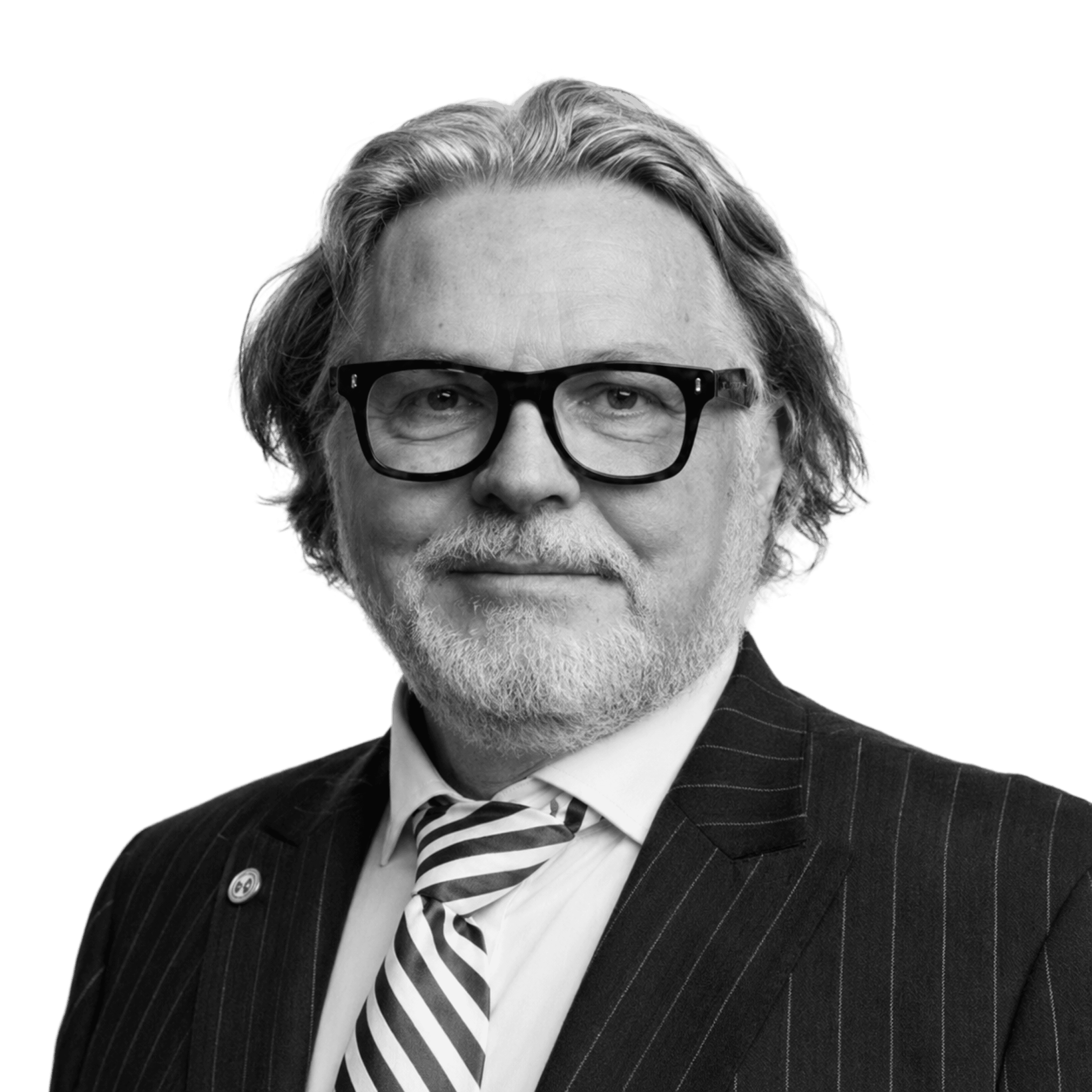 A studio headshot of a man wearing a suit and glasses