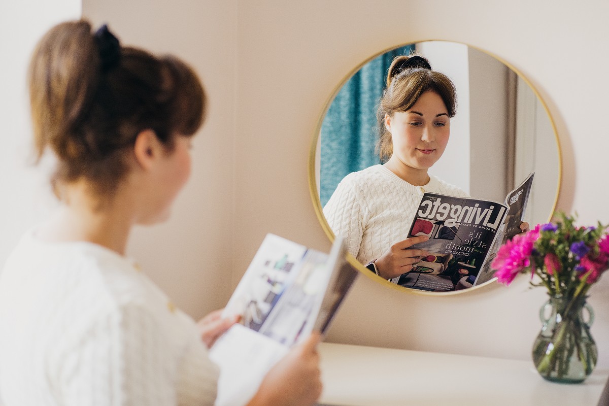 Aniko Rucz preparing a guest-ready short-term rental bedroom with attention to cleanliness and presentation