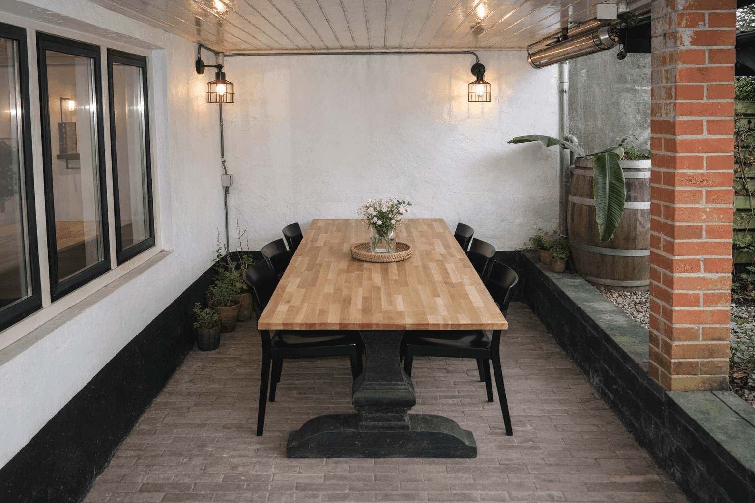 De patio van de Impact Stay met een houten tafel, sfeerlampjes en een heater