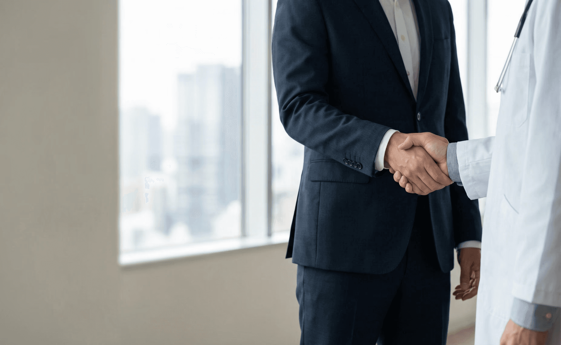 Woman looking at a computer screen in warm natural light, focused and thoughtful, with sunlight casting soft shadows on the wall behind her.