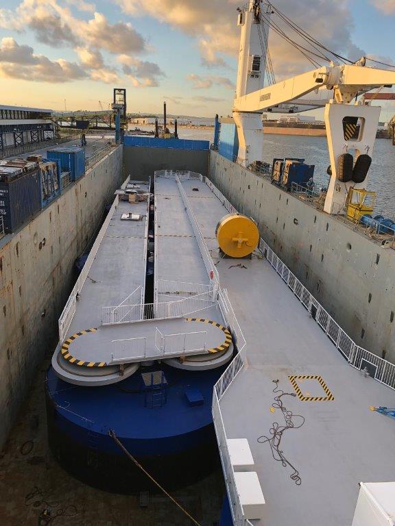 SeaWalk floating pier modules positioned inside a dry dock during construction, showing pontoons, deck surfaces and crane equipment used for assembly.