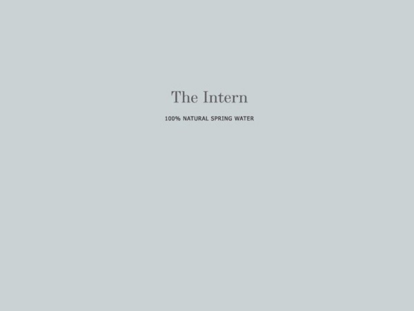 The image displays the title "The Intern" in black serif font centered on a light gray background. Below the title, the text "100% NATURAL SPRING WATER" is written in smaller black font.